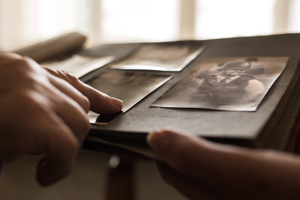 An image of fingers pointing at old photos